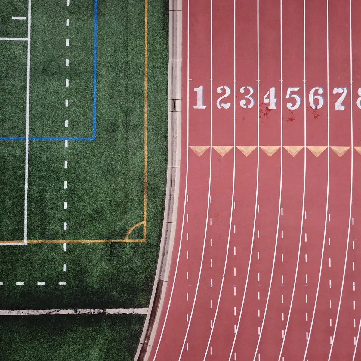Bieżnia lekkoatletyczna z lotu ptaka, ponumerowane tory na linii startu